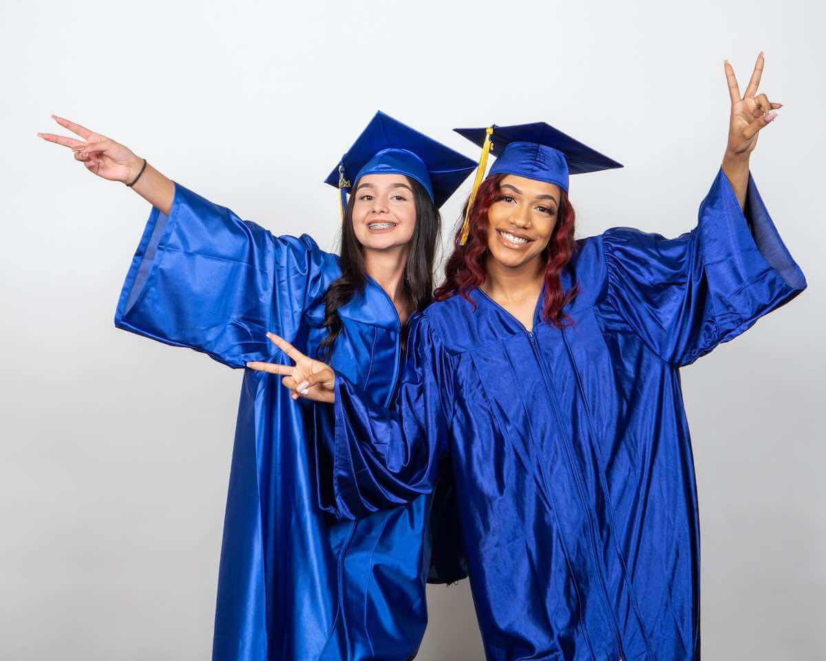 Edge High School graduates in blue cap and gown at in-person ceremony and wearing masks